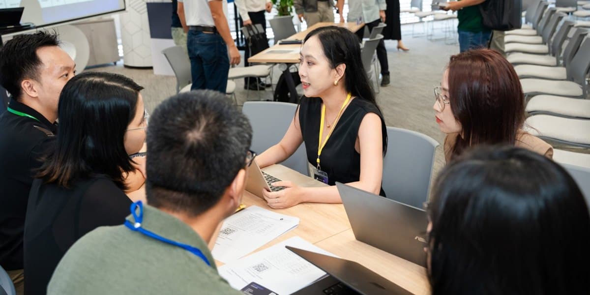 A table discussion around laptops at GenAI Open Innovation Vietnam